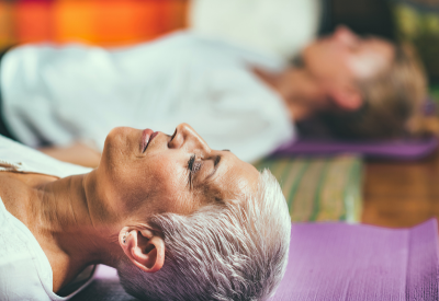 Older woman practicing yoga or meditation in class setting
