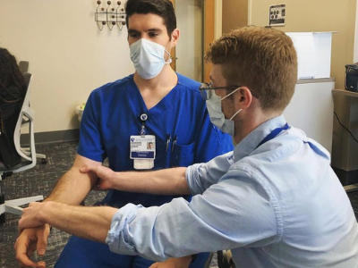 Resident Dr. Jonathan Nahmias (left), who is in the Clinician Educator Track, teaches medical student Fred Keller how to assess for catatonia. 