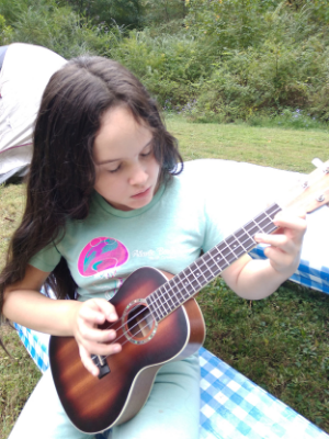 Zoe plays guitar in her backyard