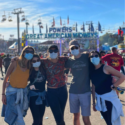 Five Psychiatry and Med-Psych residents stand in front of the entrance to the State Fair in Raleigh, NC.