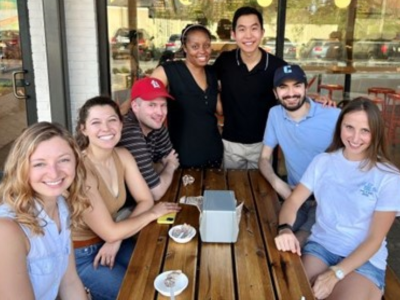 Seven med-psych residents sitting around wooden table after getting ice cream
