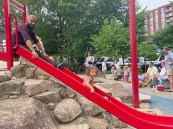 Adam and his son play on the slide near Durham Farmer's Market