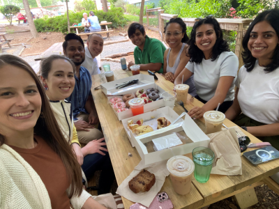 CAP fellows sitting around a table at Monuts restaurant with drinks and sweet treats on the table.