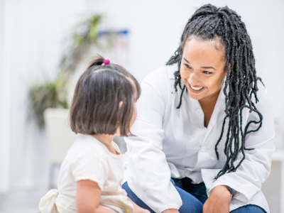 Woman talks with young girl in clinical setting
