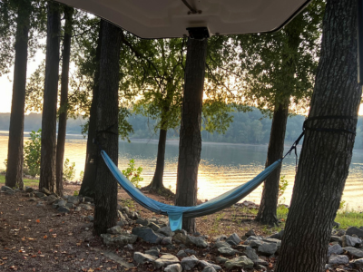 Hammock in the woods with lake in the background