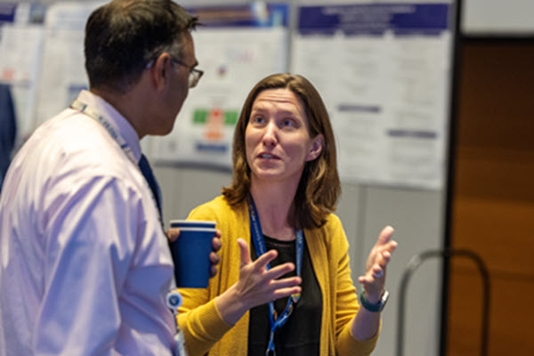 Colleen Cowperthwait discusses her project with an attendee at the poster session.