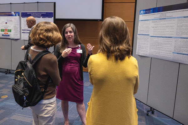 Jill Howard discusses her project with an attendee at the poster session.