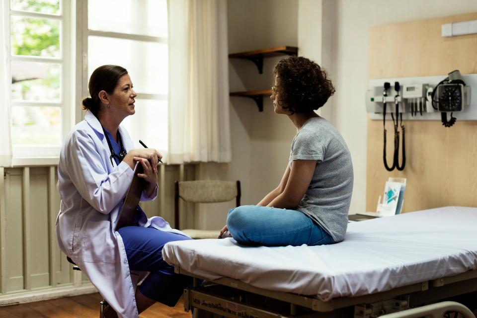 Healthcare provider talks with adolescent/young adult patient in ER setting