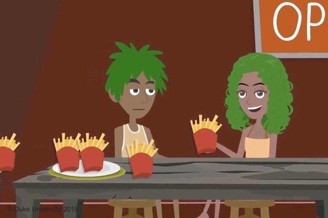 2 people in front of a table with french fries. 