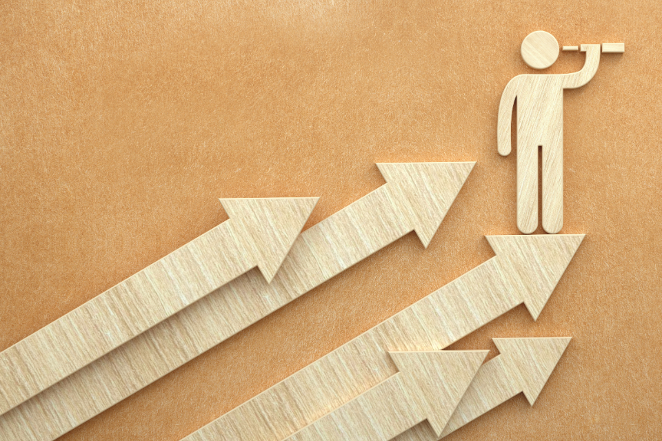 Wooden arrows pointing diagonally upward and stick figure cutout in top right with telescope