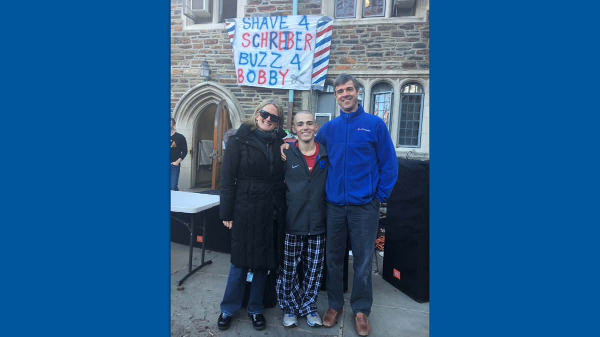 Three people standing in front of a building at Duke