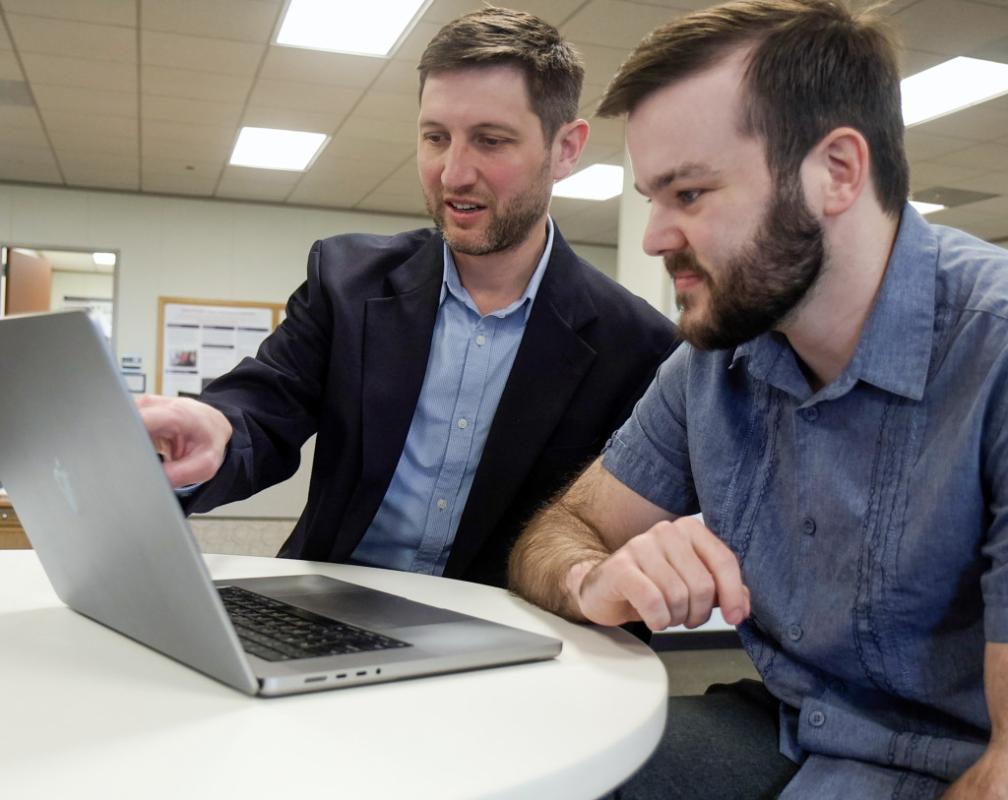 Matthew Engelhard (left) and Elliot Hill (right) looking at a computer screen.