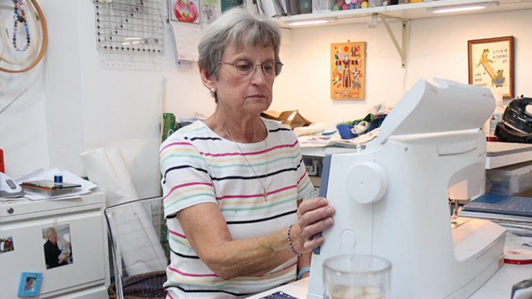 Older adult woman working at her sewing machine