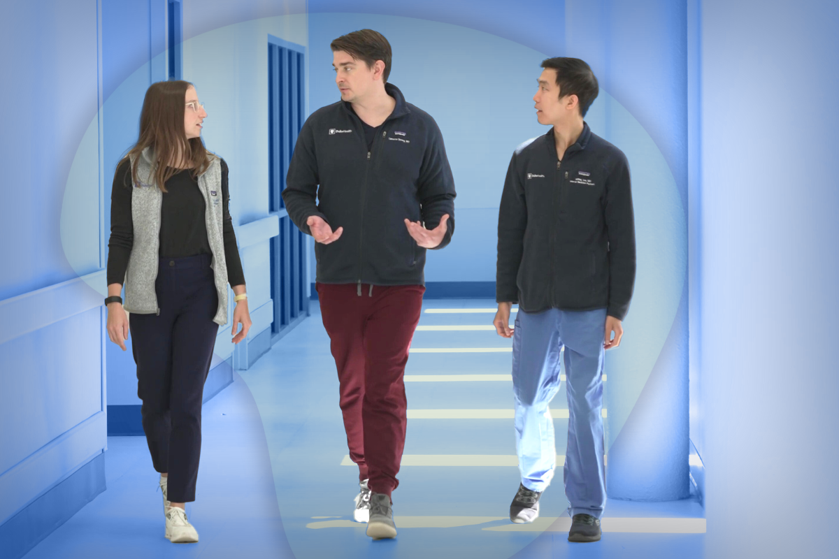 Two trainees walking with a faculty member