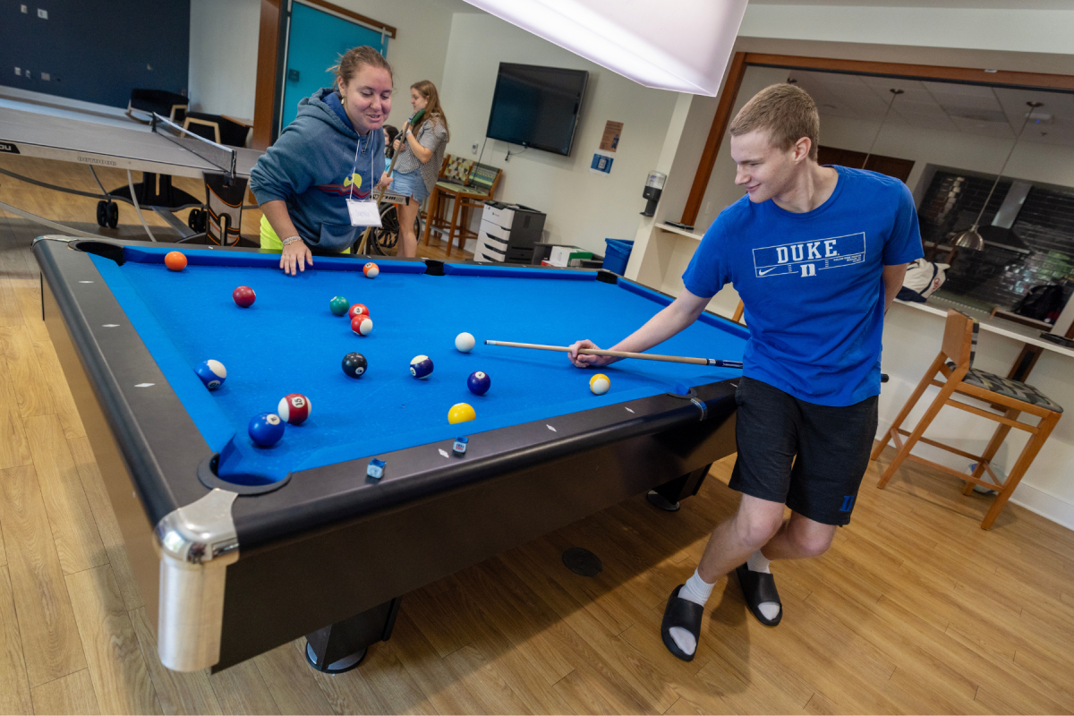 Two young adults playing pool