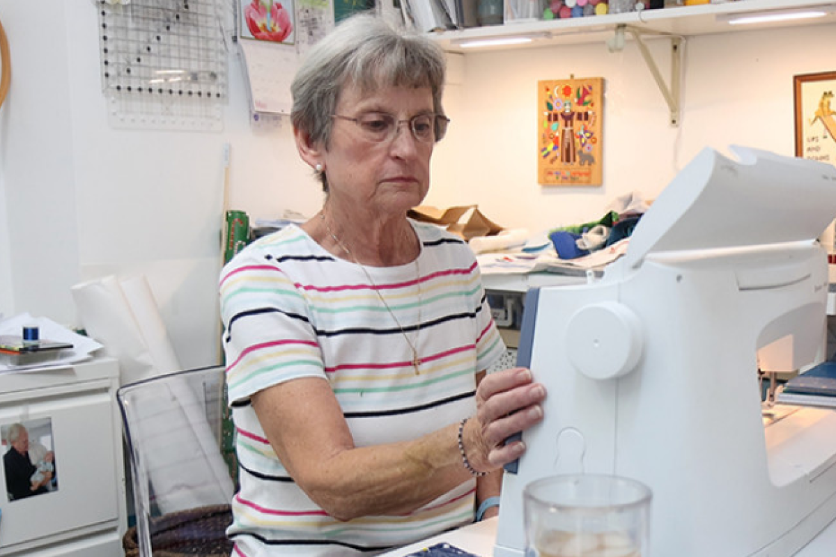 Older adult woman working at her sewing machine