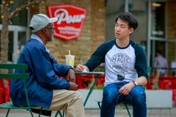 Student talking with community member in downtown Durham