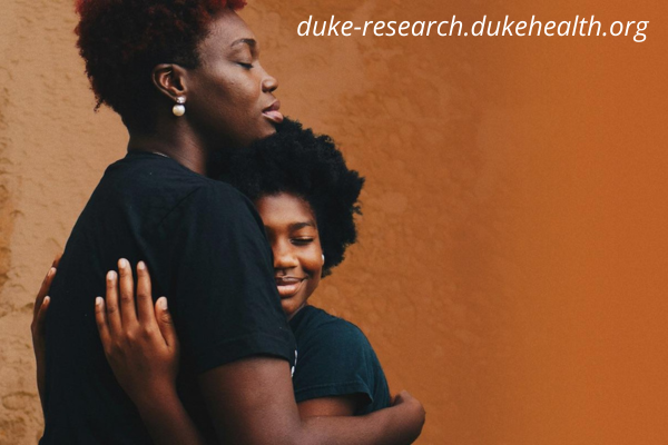 Woman hugging girl with rustic orange background. Website address: duke-research.dukehealth.org