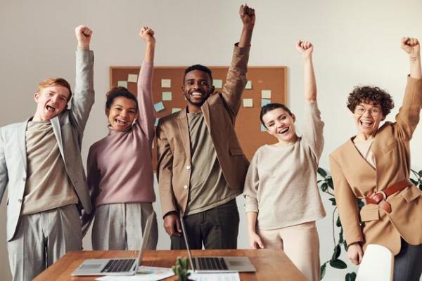 Diverse group young professionals with fists in air