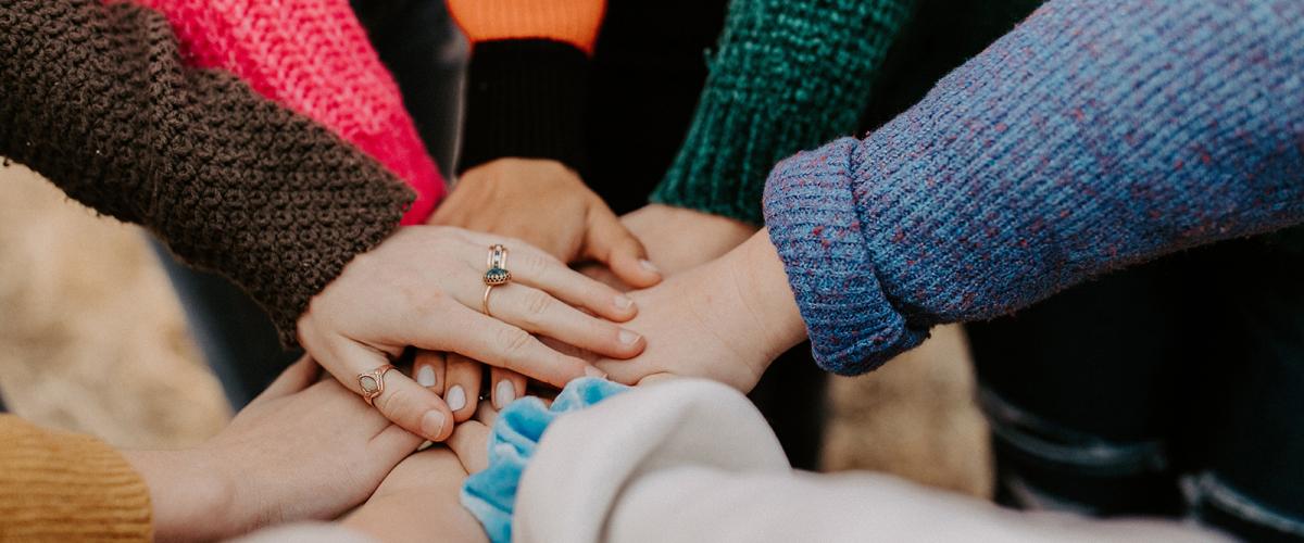 Women's hands stacked in a circle