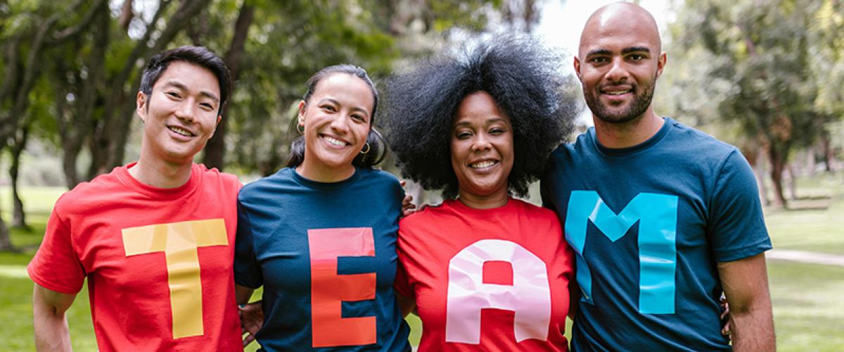 Adults in t-shirts spelling TEAM
