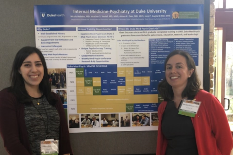 Med-Psych residents Alissa Stavig and Nicole Helmke standing in front of poster