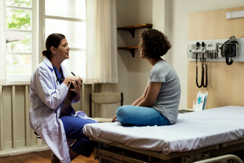 Healthcare provider talks with adolescent/young adult patient in ER setting