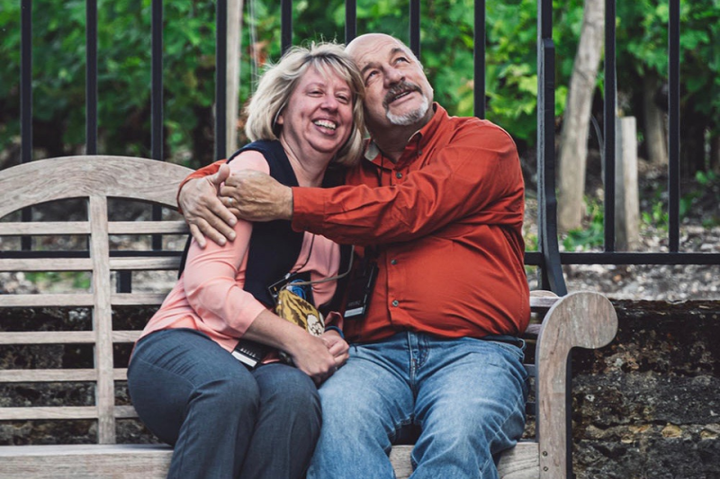 Heather & Eric Paradis sitting on a bench and hugging