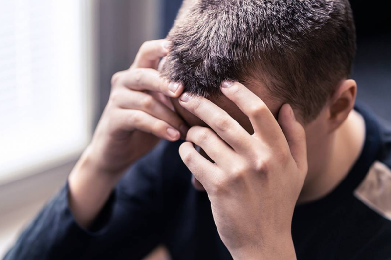 Man holding head in hands