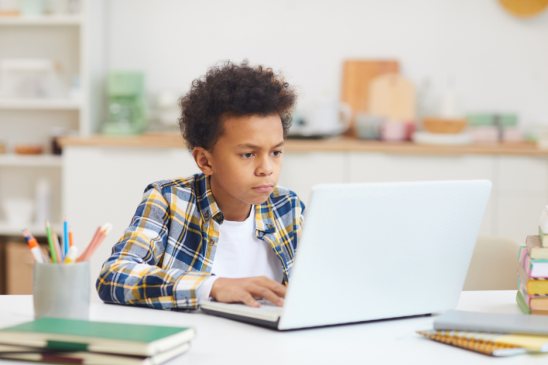 Boy focusing on something on laptop