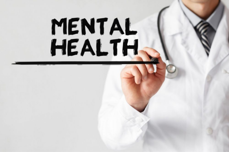 Words "Mental Health" with clinician standing behind words