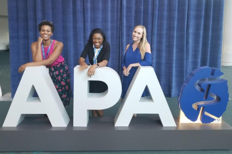 Uche Aneni (center) poses with fellow residents April Toure (left) and Heather Spain behind APA letters at APA conference