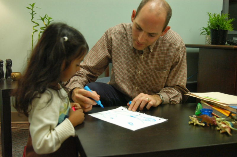 Luke Smith works with young girl at El Futuro