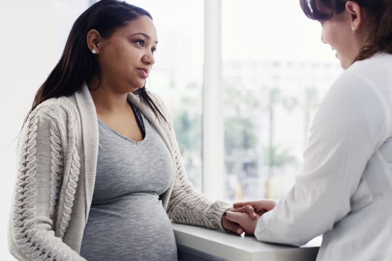 Clinical provider talking with pregnant patient