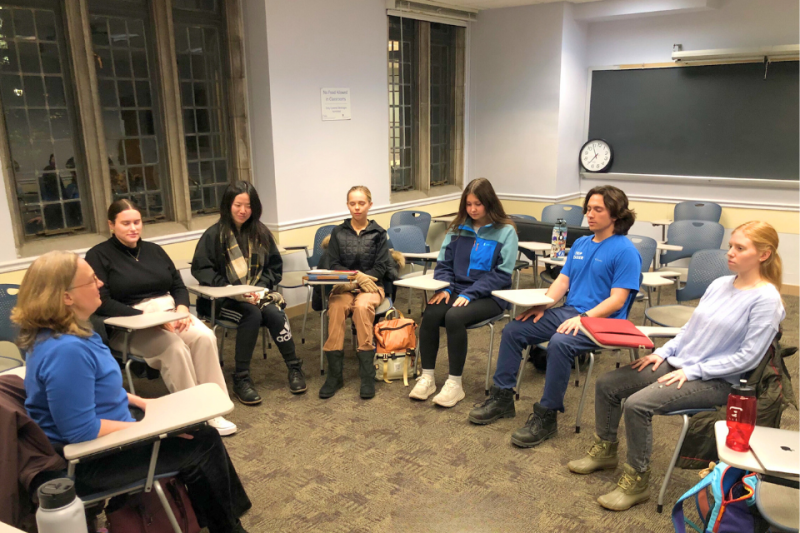 Group of college students meditating in a semi-circle