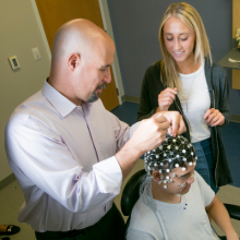 Dr. Greg Appelbaum and lab associate work with transcranial magnetic stimulation equipment