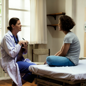 Healthcare provider talks with adolescent/young adult patient in ER setting
