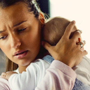Woman holding baby and looking troubled