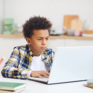 Boy focusing on something on laptop