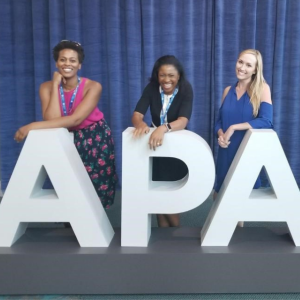 Uche Aneni (center) poses with fellow residents April Toure (left) and Heather Spain behind APA letters at APA conference