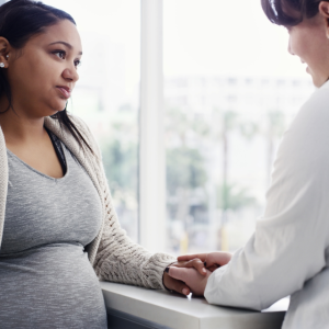 Clinical provider talking with pregnant patient