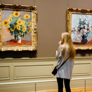 Young woman looking at paintings in a museum