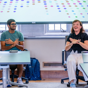 Sarah Wilbur, Duke associate professor of the practice of dance and Re-Imagining Medicine Fellow Pranav Mukund dance during a seated movement session in the Rubenstein library. Photo credit: Summer Steenberg.