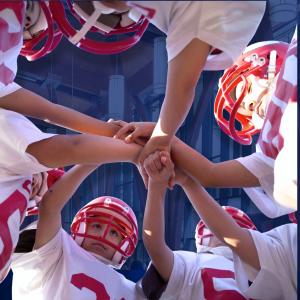 Young kids in red and white football uniforms and helmets huddled together, shot taken from below their hands. 